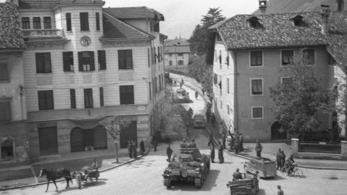 Der Grieser Platz, aus dem Stift Muri-Gries gesehen, mit der Strasse Richtung Meran. Die Aufnahme ist rückseitig von Ambros Trafojer beschriftet mit: «Deutsche Panzer sperren den Grieser Hauptplatz am 3. Mai 1945» (StiAMG, Film 187, Aufnahme Nr. 4324).