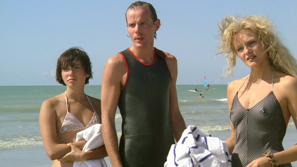 Zwei junge Frauen und ein junger Mann am Strand