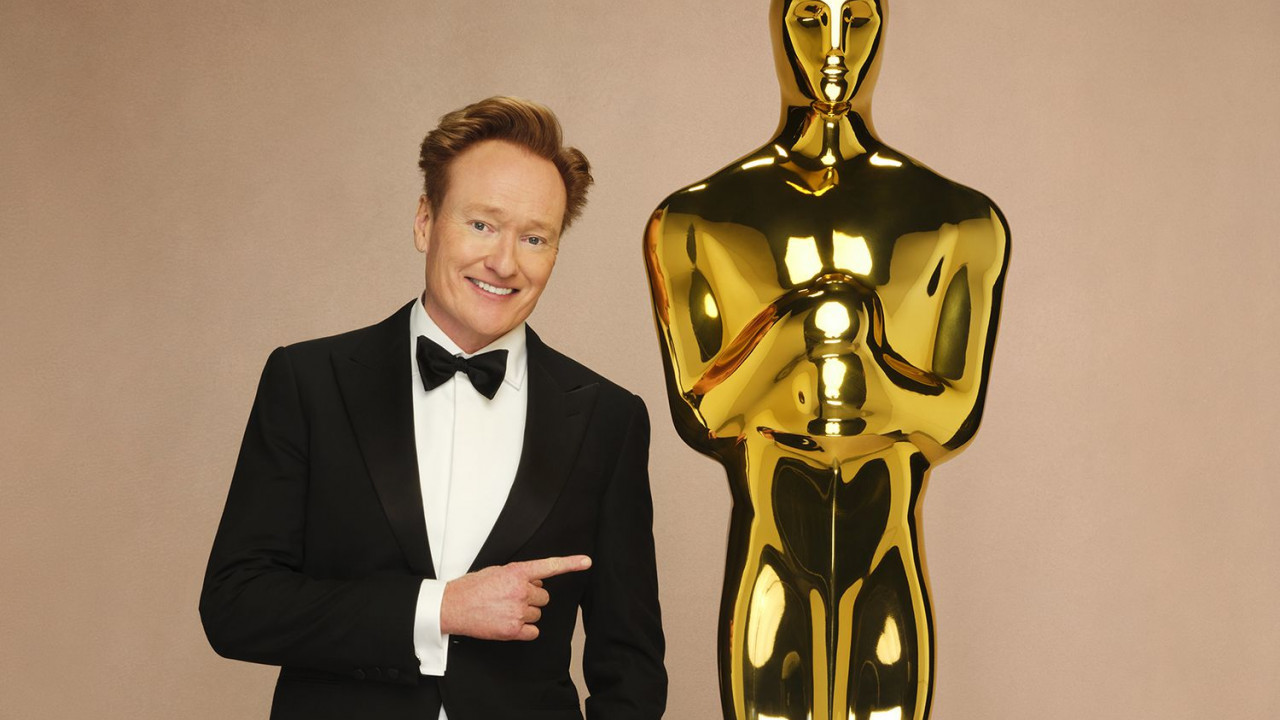 Ein Mann steht neben einer goldenen Statue