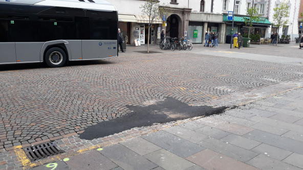 Piazza Domenicani a Bolzano, l'ennesimo buco rattoppato nei pressi della fermata dei bus sul lato sud.